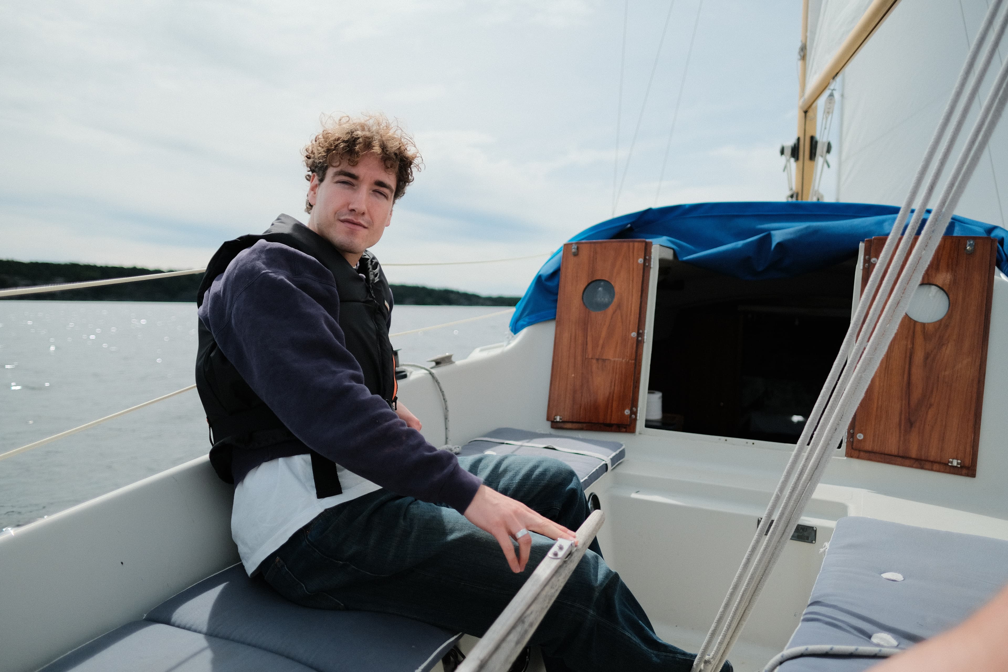 Isaak sitting aboard a sailboat.